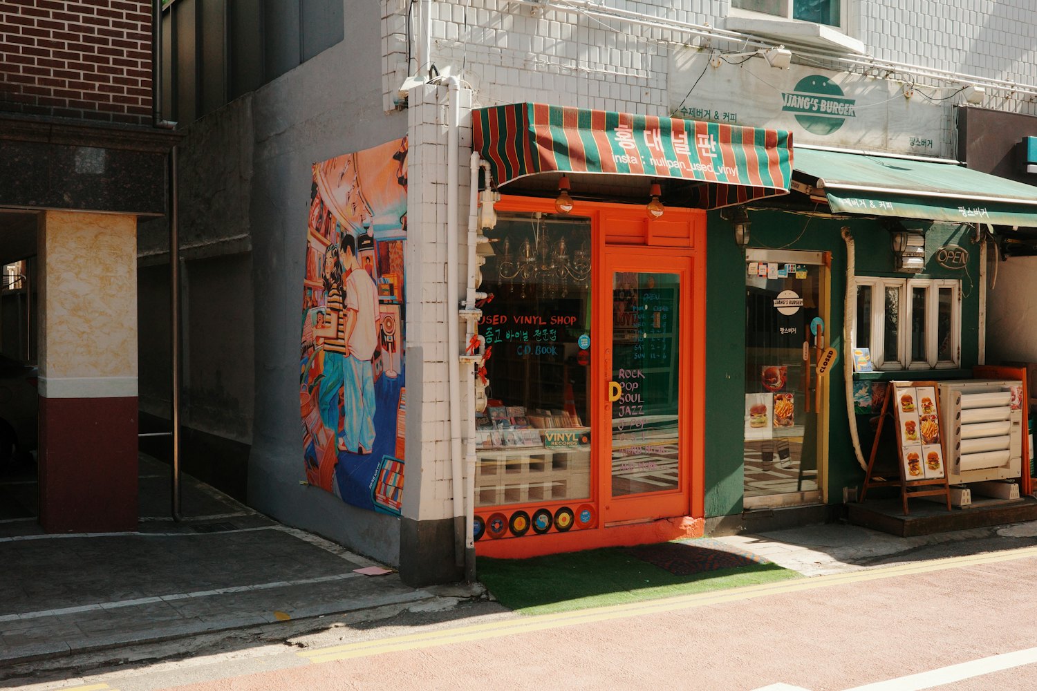 A small independent shop with an orange door and striped awning